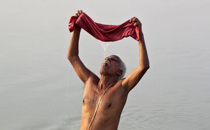 Un devoto hindú utiliza una tela para filtar agua en el río Ganges, en Allhabad (India).