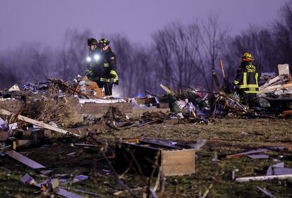 Bombeiros revistam um campo com destroço de uma casa que foi arrancada de sua fundação no Condado de St. Charles, Missouri. As comunidades ao longo da divisa entre o estado de Kentucky e Tennessee foram advertidas por vários dias de que fortes tornados eram possíveis.