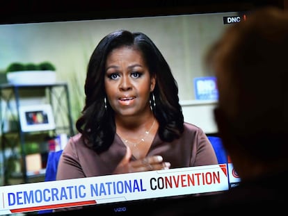 Un hombre mira el discurso de Michelle Obama en la Convención Demócrata.