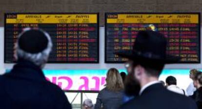 Varios ciudadanos israelíes observan en una pantalla el estado de la llegada de los vuelos, en el aeropuerto de Ben Gurion, a las afueras de Tel Aviv, en Israel. EFE/Archivo