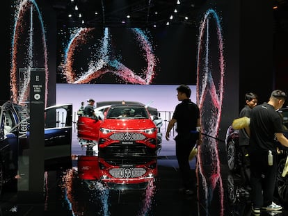 Trabajadores limpian automóviles en un stand de Mercedes-Benz.