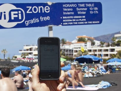 Un internauta se conecta a la red wifi gratuita de la playa de La Arena, en Tenerife.