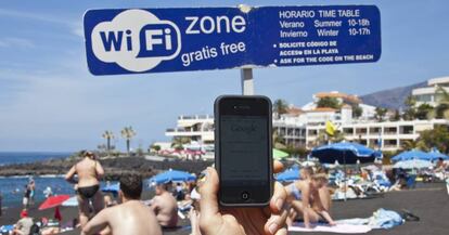 Un internauta se conecta a la red wifi gratuita de la playa de La Arena, en Tenerife.