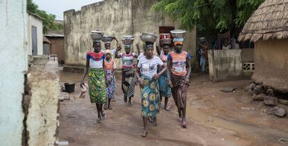 Las chicas jóvenes de Oussoubidiagna llevan en sus cabezas los platos de comida para sus padres o maridos que trabajan en los campos de alrededor.