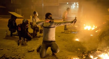 Protestors in Caracas set up street barricades and fire slingshots at police.