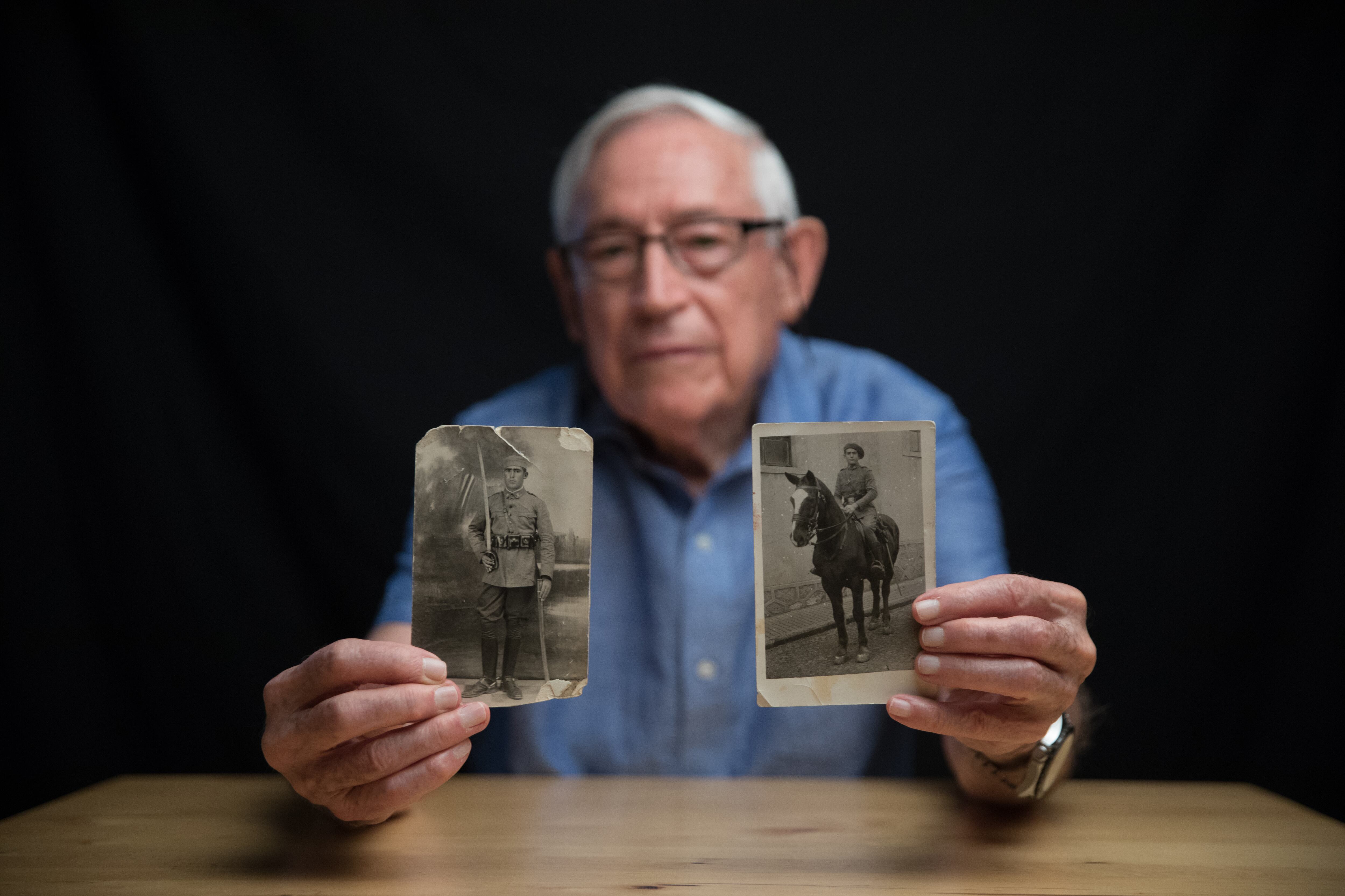 Fausto Canales posa con las fotografias de su padre Valerico Canales y su tio Victoriano Canales, enterrados en el Valle de los Caídos. 