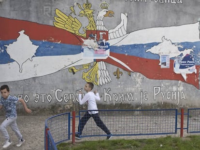 Niños jugando delante de un mural frente a símbolos serbios y rusos en el norte de Mitrovica, la zona en la que viven los serbios. El sur es la parte en la que viven los albanokosovares.