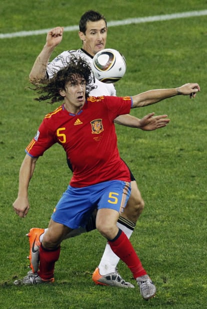 Puyol trata de controlar la pelota ante la presencia de Klose.