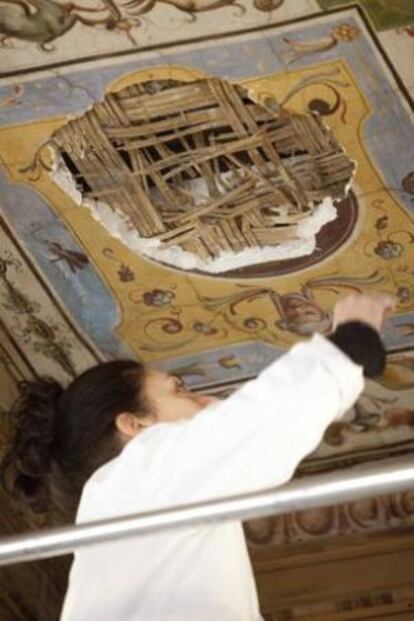 Una restauradora examina el hueco dejado por un fragmento de fresco que se ha desprendido del techo de los Uffizi.