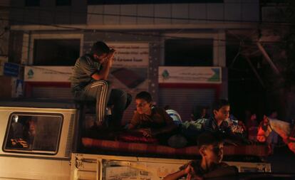 Un grupo de palestinos viajan en un vehículo cargado con sus pertenencias mientras regresan a sus casas tras el anuncio de que Israel y Hamás han logrado un acuerdo de alto el fuego permanente.