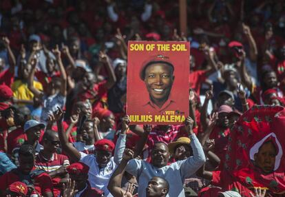 Os defensores do partido Economic Freedom Fighters (EFF) empunham cartaz eleitoral do líder Julius Malema durante uma manifestação do Dia 1º de Maio em Alexandra Township, Joanesburgo (África do Sul).