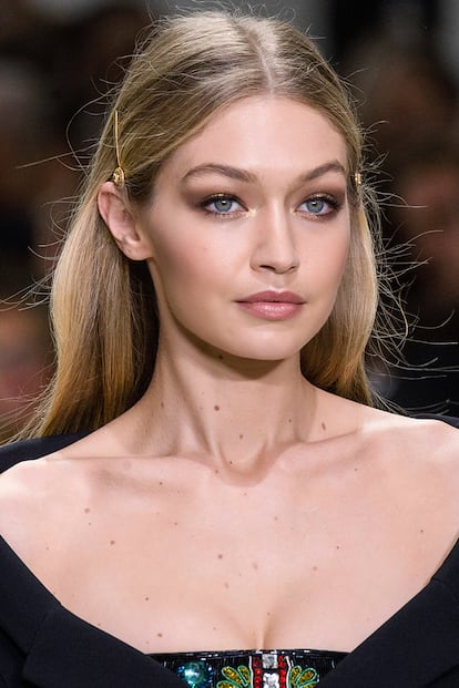 Gigi Hadid nos inspira de la mano de Versace con uno de los peinados más sencillos de la lista: melena al viento y horquillas doradas en los laterales de la cabeza.