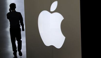 Un hombre habla por teléfono junto a un logotipo de Apple