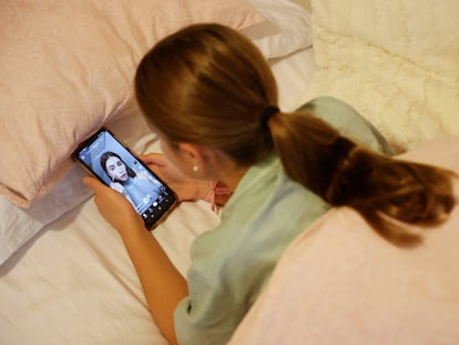 Una adolescente observa a una influencer en TikTok en su teléfono móvil.
