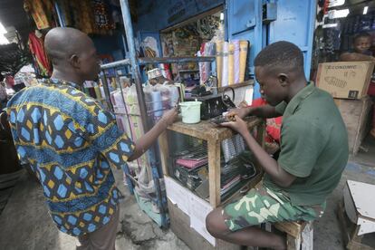 Liberia. Dos hombres jóvenes reparan teléfonos móviles en Sumo Technology, en Monrovia, el 25 de marzo de 2020. Debido a la alta tasa de desempleo, los jóvenes participan en el negocio de reparación de teléfonos para buscar medios de vida diarios para ellos y sus familias. El país depende de los móviles para las telecomunicaciones, ya que años de guerra civil lo han dejado sin infraestructura telefónica de línea fija.