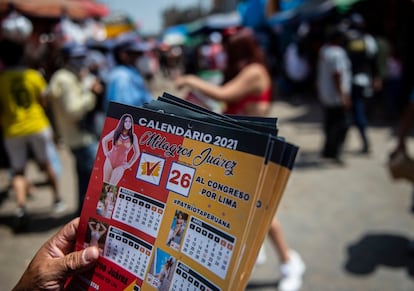 Un hombre reparte calendarios con una imagen de la candidata al Congreso peruano Milagros Juárez, en Lima el 4 de abril.