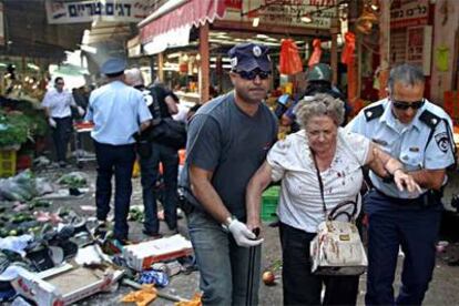 Una mujer es ayudada a abandonar el lugar de la explosión.