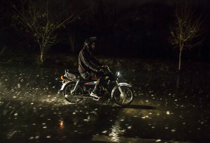 Un hombre circula con su moto durante una fuerte tormenta en Islamabad (Paquistán).