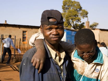 Dos amigos se r&iacute;en en el asentamiento temporal en Bapsfontein, a 80 kil&oacute;metros de Johannesburgo (Sud&aacute;frica).