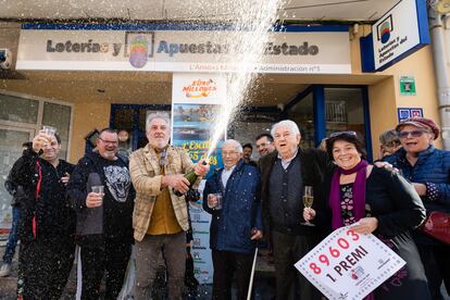 Los propietarios de la administración número 1 de L'Escala (Girona) celebran con agraciados y curiosos tras haber repartido todas las 40 series del primer premio de la Lotería de El Niño este viernes. 