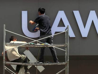 Trabajadores poniendo el rótulo en una tienda de nueva construcción en la provincia china de Yunnan.