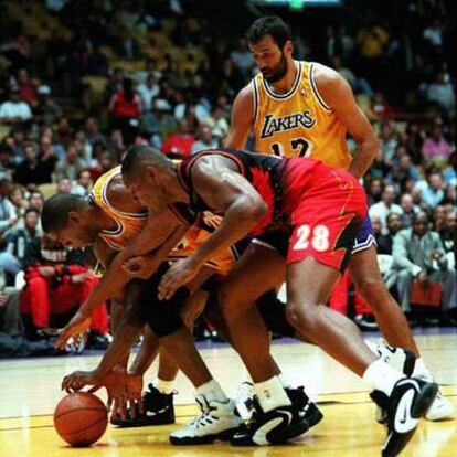 Arriba, Divac junto a Magic Johnson y Lang (de Atlanta) en un partido de los Lakers de 1996.