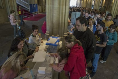 Un numeroso grupo de personas hace cola para votar en el colegio electoral instalado en la Universidad Central de Barcelona.