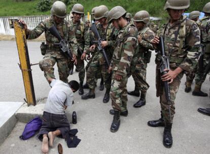 Un soldado se hace limpiar las botas en el paso de Las Manos.