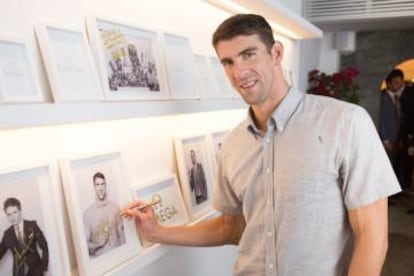 Phelps firma su foto en blanco y negro en el pequeño 'hall of fame' de OMEGA House en la villa olímpica de Río 2016.