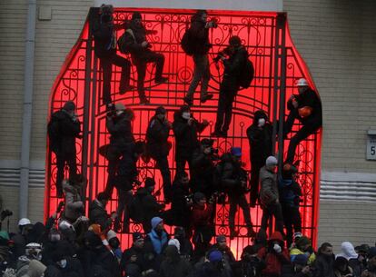 Manifestantes escalan una de las puertas cerca del edificio presidencial durante las protestas.