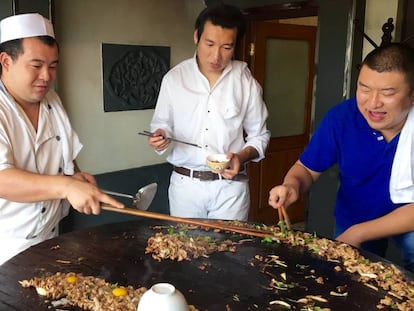 Shao Bao y sus dos cocineros durantes los toques finales de la barbacoa.