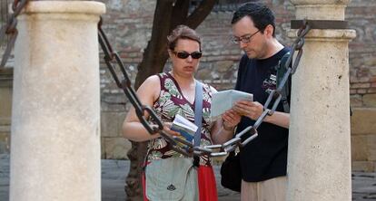 Dos turistas consultan su plano cerca de la catedral de Málaga.