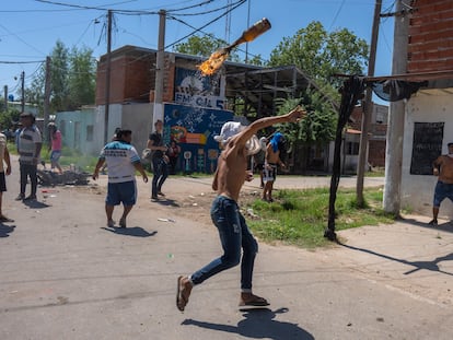 Un vecino del barrio Los Pumitas, en Rosario (Argentina), lanza un cóctel molotov a la casa de un hombre acusado de ser narcotraficante, este lunes.