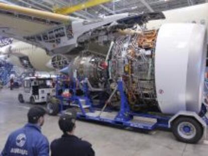 Dos trabajadores participan en el montaje de los dos motores Rolls-Royce Trent XWB del nuevo modelo de avi&oacute;n Airbus A350 XWB, en Colomiers, Francia.