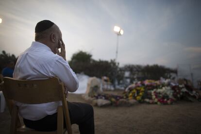 Un hombre llora junto a la tumba del ex primer ministro Ariel Sharon durante su funeral en Havat Hashikmim, Israel.