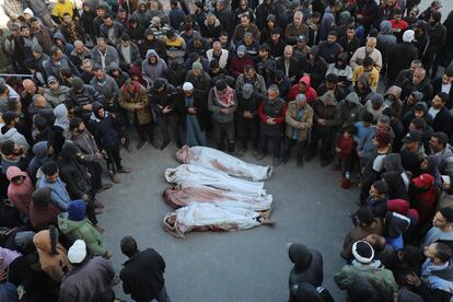 Palestinos rezan alrededor de los cuerpos de cuatro muertos en ataques israelíes frente a la morgue del Hospital Al-Aqsa en Gaza, este jueves.