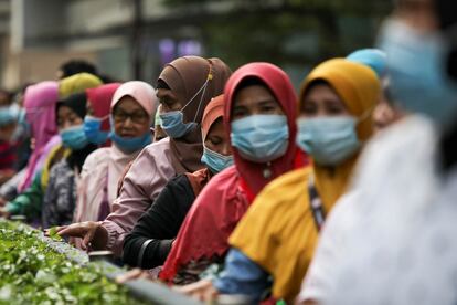 Una cola de mujeres esperan un autobús en Kuala Lumpur (Malasia).