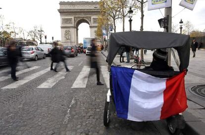 Una bandera colgada de un triciclo turístico en París.