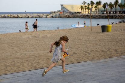 Una niña con una bandera catalana corre por la Barceloneta en Barcelona. Los menores se han situado en el centro de la crisis institucional que atraviesa España. La Fiscalía y el Ministerio de Educación han pedido a la Generalitat que evite la asistencia de menores en horario lectivo a las protestas a favor del referéndum.