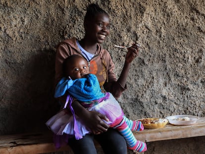 Una madre adolescente keniana almuerza con su bebé en brazos durante su pausa para el almuerzo en la Escuela Secundaria de Niñas Serene Haven, en Kiawara en Kieni, Nyeri, Kenia, el 10 de febrero de 2021.