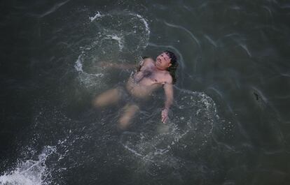 Un hombre indio se enfría con un baño en el río Yamuna de Allahabad.