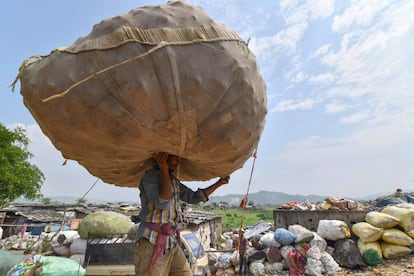 Trabalhador indiano carrega um enorme saco cheio de garrafas PET em um dos maiores lixões a céu aberto do noroeste da Índia, na segunda-feira. Nesta terça-feira, 5 de junho, é celebrado o Dia Mundial do Meio Ambiente 2018, cujo tema este ano é focado no uso e acúmulo do plástico no planeta.