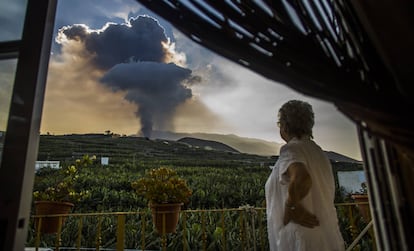 Una mujer contempla la columna de humo lanzada por el volcán de La Palma, este jueves.