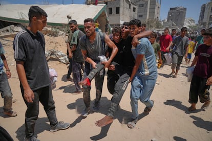Palestinos transportan a un hombre que resultó herido mientras recogía ayuda humanitaria, este jueves en Gaza.