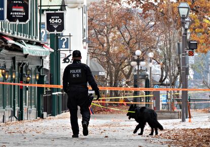 Un policía camina cerca de donde un hombre mató a dos personas en Quebec, este domingo.