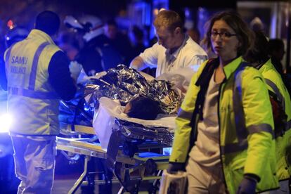 Una persona es evacuada después de los disparos en la sala de fiestas Bataclan. El presidente francés Hollande ha declarado el estado de emergencia y ha anunciado el cierre de las fronteras del país.