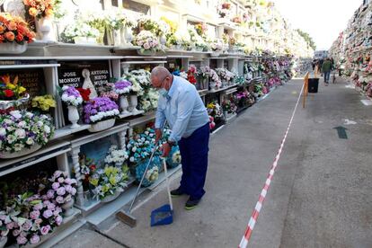 Un hombre limpia las inmediaciones de las lápidas de las tumbas de sus fallecidos en el cementerio de Algeciras.