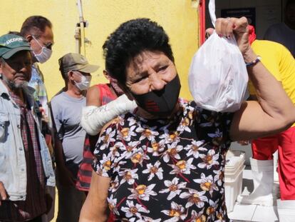 Una mujer muestra sus bolsas con huesos a las afueras de un expendio de carne el 21 de julio en Cuiabá.
