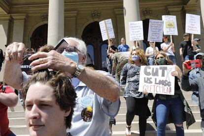 El barbero Karl Manke corta el pelo en la "Operación Corte de Pelo" fuera del Capitolio del Estado de Michigan el 20 de mayo de 2020.