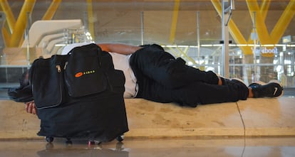 Una persona duerme en la terminal cuatro del Aeropuerto Adolfo Suárez de Madrid.